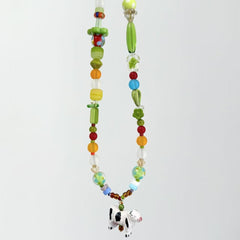 Colorful beaded necklace with a cow pendant on a white background
